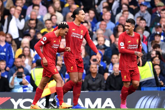 LONDON, ENGLAND - SEPTEMBER 22: Trent Alexander-Arnold of Liverpool celebrates with teammates Virgil van Dijk and Roberto Firmino after scoring his team's first goal during the Premier League match between Chelsea FC and Liverpool FC at Stamford Bridge on September 22, 2019 in London, United Kingdom. (Photo by Laurence Griffiths/Getty Images)