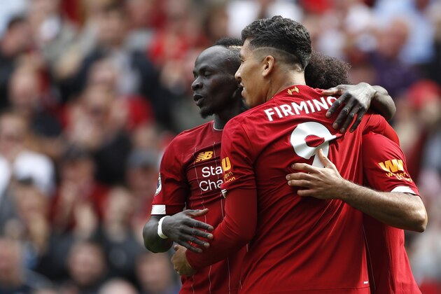 Liverpool's Sadio Mane, left, celebrates with Liverpool's Roberto Firmino, center, and Liverpool's Mohamed Salah, right, after scoring his sides second goal during the English Premier League soccer match between Liverpool and Newcastle at Anfield stadium in Liverpool, England, Saturday, Sept. 14, 2019. (AP Photo/Rui Vieira)