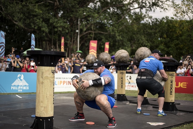 Hafthor Julius Bjornsson of Iceland (C) and Mateusz Kieliszkowski (R) of Poland lift concrete spheres during the Atlas Stones competition of the 2018 World's Strongest Man in Manila on May 6, 2018. (Photo by NOEL CELIS / AFP) / RESTRICTED TO EDITORIAL USE        (Photo credit should read NOEL CELIS/AFP/Getty Images)