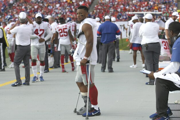 New York Giants running back Saquon Barkley stands on crutches in the bench area after getting injured against the Tampa Bay Buccaneers during the first half of an NFL football game Sunday, Sept. 22, 2019, in Tampa, Fla. (AP Photo/Jason Behnken)