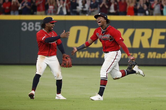 Atlanta Braves second baseman Ozzie Albies (1), left, and center fielder Ronald Acuna Jr. (13) react after defeating the San Francisco Giants in a baseball game to clinch the NL East baseball title Friday, Sept. 20, 2019, in Atlanta. (AP Photo/John Bazemore)
