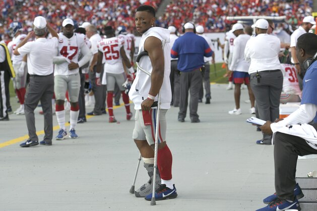 New York Giants running back Saquon Barkley stands on crutches in the bench area after getting injured against the Tampa Bay Buccaneers during the first half of an NFL football game Sunday, Sept. 22, 2019, in Tampa, Fla. (AP Photo/Jason Behnken)
