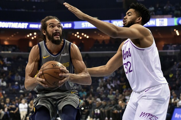 Memphis Grizzlies center Joakim Noah, left, handles the ball against Minnesota Timberwolves center Karl-Anthony Towns (32) in the first half of an NBA basketball game Saturday, March 23, 2019, in Memphis, Tenn. (AP Photo/Brandon Dill)