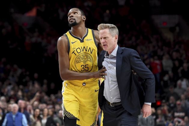 Golden State Warriors forward Kevin Durant, left, helps escort coach Steve Kerr after Kerr was ejected during the second half of the team's NBA basketball game against the Portland Trail Blazers in Portland, Ore., Wednesday, Feb. 13, 2019. The Blazers won 129-107. (AP Photo/Steve Dykes)