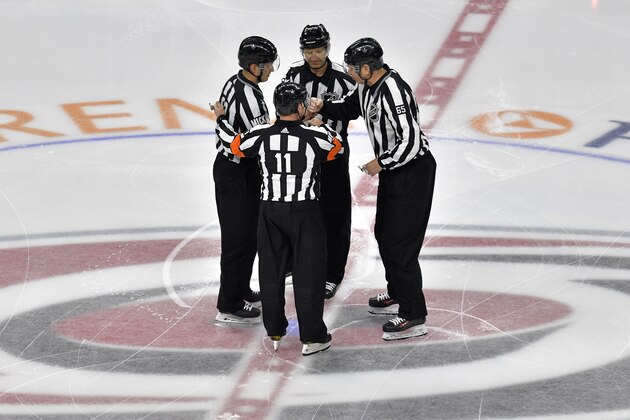 RALEIGH, NORTH CAROLINA - MAY 14: Referee Kelly Sutherland #11, linesman Trent Knorr #63 and linesman Pierre Racicot #65 talk during the first period in Game Three between the Boston Bruins and the Carolina Hurricanes in the Eastern Conference Finals during the 2019 NHL Stanley Cup Playoffs at PNC Arena on May 14, 2019 in Raleigh, North Carolina. (Photo by Grant Halverson/Getty Images)