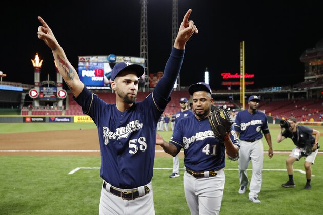 CINCINNATI, OH - SEPTEMBER 25: Alex Claudio #58 and Junior Guerra #41 of the Milwaukee Brewers celebrate after clinching a playoff berth following a 9-2 win over the Cincinnati Reds at Great American Ball Park on September 25, 2019 in Cincinnati, Ohio. (Photo by Joe Robbins/Getty Images)