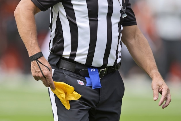 An NFL referee puts away his penalty flag after a penalty in the first half of an NFL football game between the Tennessee Titans and the Cleveland Browns, Sunday, Sept. 8, 2019, in Cleveland. (AP Photo/David Richard)