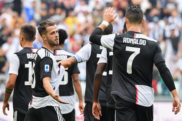 Juventus' Bosnian midfielder Miralem Pjanic (L) celebrates with Juventus' Portuguese forward Cristiano Ronaldo (R) after opening the scoring during the Italian Serie A football match Juventus vs Spal on September 28, 2019 at the Juventus stadium in Turin. (Photo by Andreas SOLARO / AFP)        (Photo credit should read ANDREAS SOLARO/AFP/Getty Images)