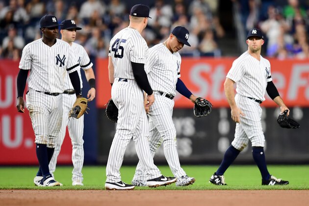 NEW YORK, NEW YORK - SEPTEMBER 20: Gleyber Torres #25 of the New York Yankees gets up and walks with his teammates after sliding in the outfield grass while fielding a ball during the fourth inning of their game against the Toronto Blue Jays at Yankee Stadium on September 20, 2019 in the Bronx borough of New York City. Torres exited the game in the sixth inning. (Photo by Emilee Chinn/Getty Images)