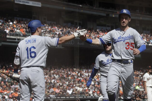 Los Angeles Dodgers' Cody Bellinger (35) is congratulated by Will Smith (16) after scoring against the San Francisco Giants during the first inning of a baseball game in San Francisco, Sunday, Sept. 29, 2019. (AP Photo/Jeff Chiu)