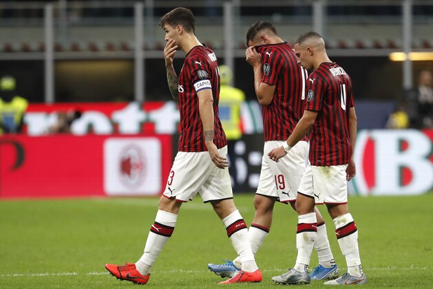 From left, AC Milan's Alessio Romagnoli, AC Milan's Theo Hernandez, AC Milan's Ismael Bennacer walk on the pitch at the end of the Serie A soccer match between AC Milan and Fiorentina, at the San Siro stadium in Milan, Italy, Sunday, Sept. 29, 2019. (AP Photo/Antonio Calanni)