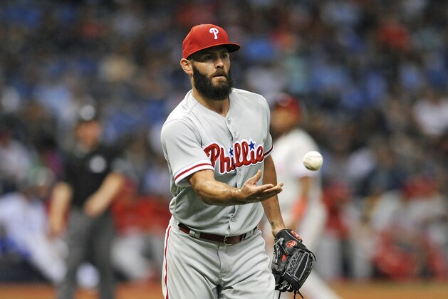 Philadelphia Phillies starter Jake Arrieta flips the ball to first baseman Carlos Santana after fielding a ground ball to the mound hit by Tampa Bay Rays' Matt Duffy during the sixth inning of a baseball game Saturday, April 14, 2018, in St. Petersburg, Fla. (AP Photo/Steve Nesius)
