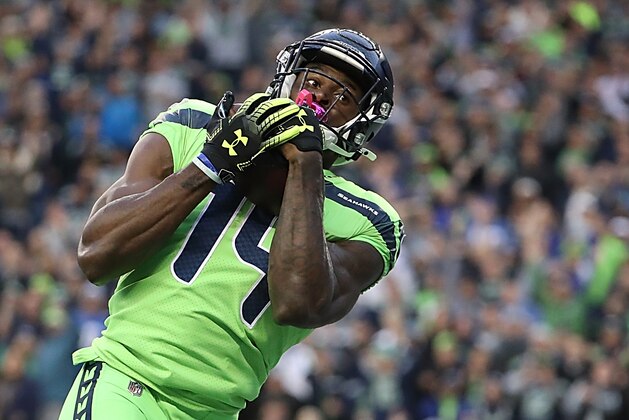 SEATTLE, WASHINGTON - OCTOBER 03: D.K. Metcalf #14 of the Seattle Seahawks completes a pass to score a touchdown in the second quarter of the game against the Los Angeles Rams  at CenturyLink Field on October 03, 2019 in Seattle, Washington. (Photo by Abbie Parr/Getty Image