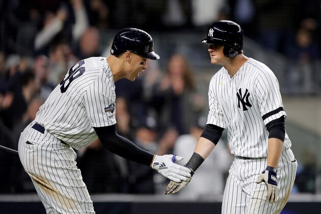 NEW YORK, NEW YORK - OCTOBER 04: DJ LeMahieu #26 of the New York Yankees celebrates with teammate Aaron Judge #99 after scoring a solo home run against Cody Stashak #61 of the Minnesota Twins during the sixth inning in game one of the American League Division Series at Yankee Stadium on October 04, 2019 in New York City. (Photo by Elsa/Getty Images)