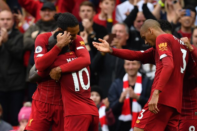 Liverpool's Senegalese striker Sadio Mane (2L) celebrates with Liverpool's Dutch defender Virgil van Dijk (L) after he scored his team's first goal during the English Premier League football match between Liverpool and Leicester City at Anfield in Liverpool, north west England on October 5, 2019. (Photo by Paul ELLIS / AFP) / RESTRICTED TO EDITORIAL USE. No use with unauthorized audio, video, data, fixture lists, club/league logos or 'live' services. Online in-match use limited to 120 images. An additional 40 images may be used in extra time. No video emulation. Social media in-match use limited to 120 images. An additional 40 images may be used in extra time. No use in betting publications, games or single club/league/player publications. /  (Photo by PAUL ELLIS/AFP via Getty Images)