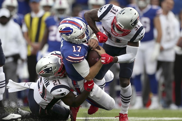 New England Patriots defenders Jonathan Jones (31) and Duron Harmon (21) tackle Buffalo Bills quarterback Josh Allen (17) in the second half of an NFL football game, Sunday, Sept. 29, 2019, in Orchard Park, N.Y. Allen left the field after the play. (AP Photo/Ron Schwane)