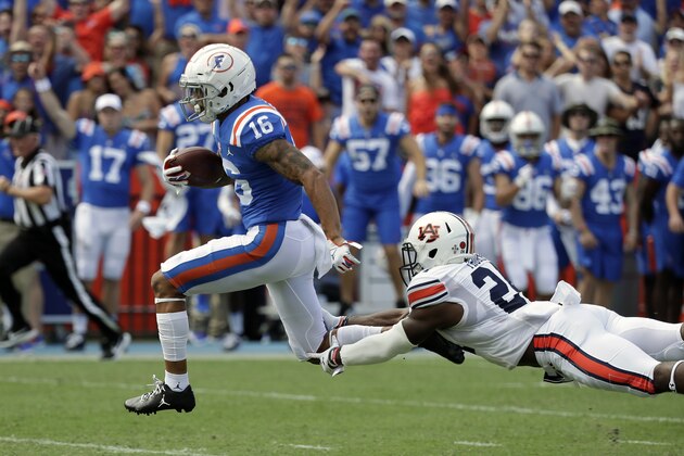 Florida wide receiver Freddie Swain (16) outruns a tackle by Auburn defensive back Daniel Thomas on his way to a 64-yard touchdown during the first half of an NCAA college football game, Saturday, Oct. 5, 2019, in Gainesville, Fla. (AP Photo/John Raoux)