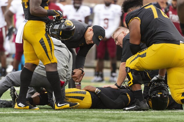 Missouri head coach Barry Odom, top, holds the hand of his quarterback Kelly Bryant as he lays on the field after he was injured during the second quarter of an NCAA college football game against Troy Saturday, Oct. 5, 2019, in Columbia, Mo. (AP Photo/L.G. Patterson)