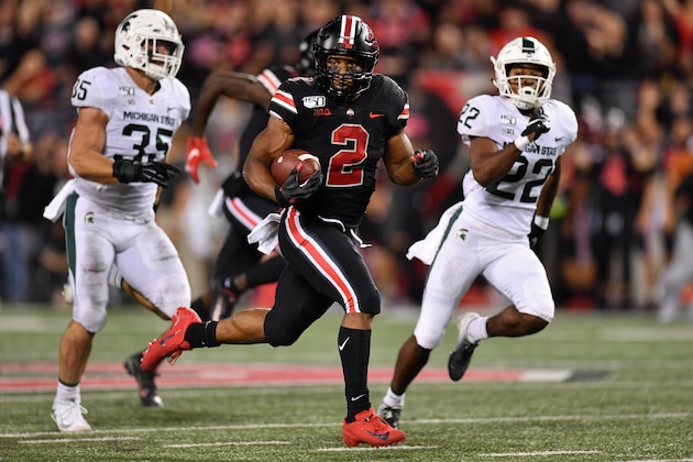 COLUMBUS, OH - OCTOBER 5:  J.K. Dobbins #2 of the Ohio State Buckeyes takes off on a 67-yard touchdown run in the second quarter as Joe Bachie #35 of the Michigan State Spartans and Josiah Scott #22 of the Michigan State Spartans give pursuit at Ohio Stadium on October 5, 2019 in Columbus, Ohio.  (Photo by Jamie Sabau/Getty Images)