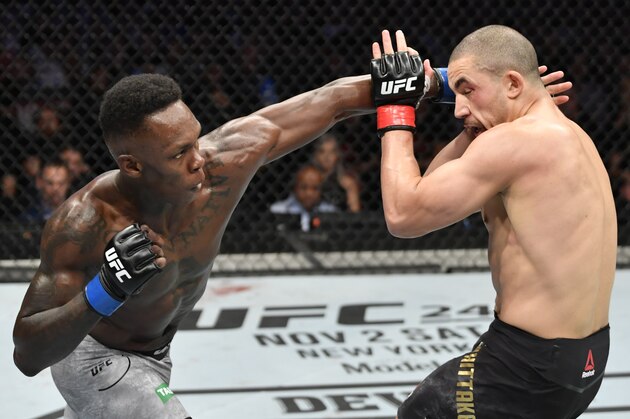 MELBOURNE, AUSTRALIA - OCTOBER 06:  (L-R) Israel Adesanya of Nigeria punches Robert Whittaker of New Zealand in their UFC middleweight championship fight during the UFC 243 event at Marvel Stadium on October 06, 2019 in Melbourne, Australia. (Photo by Jeff Bottari/Zuffa LLC/Zuffa LLC via Getty Images)