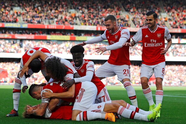 Asenal's Brazilian defender David Luiz (C) celebrates with teammates after scoring the opening goal of the English Premier League football match between Arsenal and Bournemouth at the Emirates Stadium in London on October 6, 2019. (Photo by Tolga AKMEN / AFP) / RESTRICTED TO EDITORIAL USE. No use with unauthorized audio, video, data, fixture lists, club/league logos or 'live' services. Online in-match use limited to 120 images. An additional 40 images may be used in extra time. No video emulation. Social media in-match use limited to 120 images. An additional 40 images may be used in extra time. No use in betting publications, games or single club/league/player publications. /  (Photo by TOLGA AKMEN/AFP via Getty Images)