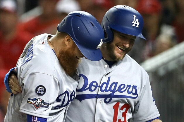WASHINGTON, DC - OCTOBER 06: Max Muncy #13 of the Los Angeles Dodgers celebrates with teammate Justin Turner #10 after scoring on a three run home run by Turner during the sixth inning of Game 3 of the NLDS against the Washington Nationals at Nationals Park on October 06, 2019 in Washington, DC. (Photo by Rob Carr/Getty Images)