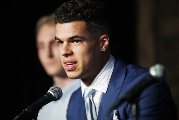 FILE--in this Friday, June 22, 2018, file photo, Michael Porter Jr., the Denver Nuggets first-round pick in the 2018 draft, jokes with reporters as one of the team's two second-round selections, Thomas Welsh, listens during a news conference in Denver. While the Nuggets do not have a pick in the 2019 draft, the team is looking at Porter, who sat out last season as he recovered from back surgery, to suit up for Denver during the NBA Summer League next month. (AP Photo/David Zalubowski, File)