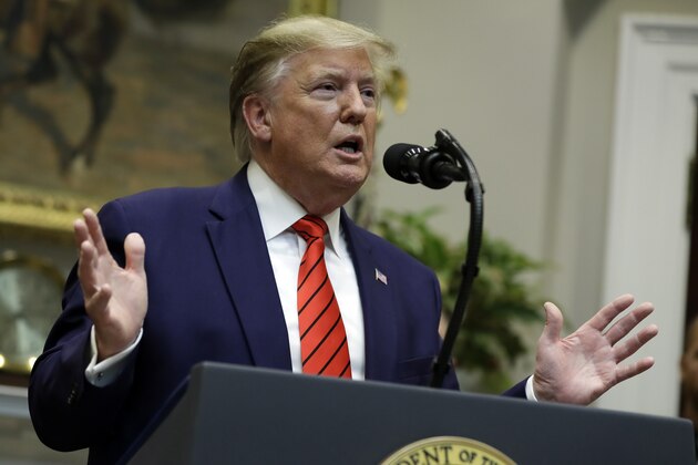 President Donald Trump answers questions from reporters during an event on