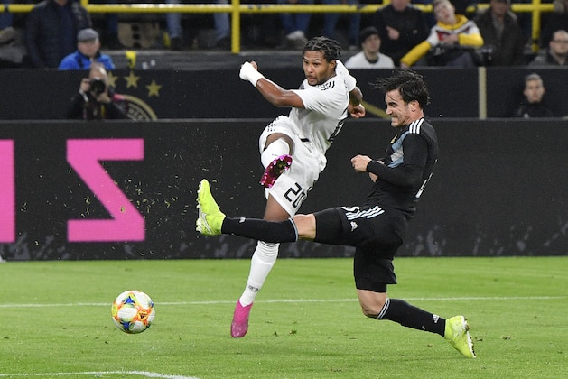Germany's Serge Gnabry, left, takes a shot at goal next to Argentina's Nicolas Tagliafico during the international friendly soccer match between Germany and Argentina at the Signal Iduna Park stadium in Dortmund, Germany, Wednesday, Oct. 9, 2019. (AP Photo/Martin Meissner)