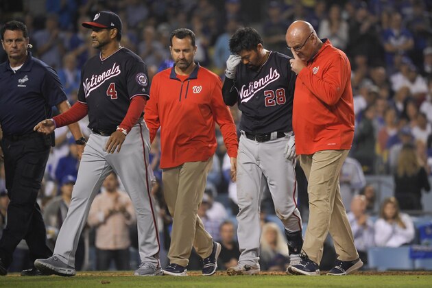 Washington Nationals' Kurt Suzuki (28) is helped off the field after being hit by a pitch during the seventh inning in Game 5 of the baseball team's National League Division Series against the Los Angeles Dodgers on Wednesday, Oct. 9, 2019, in Los Angeles. (AP Photo/Mark J. Terrill)