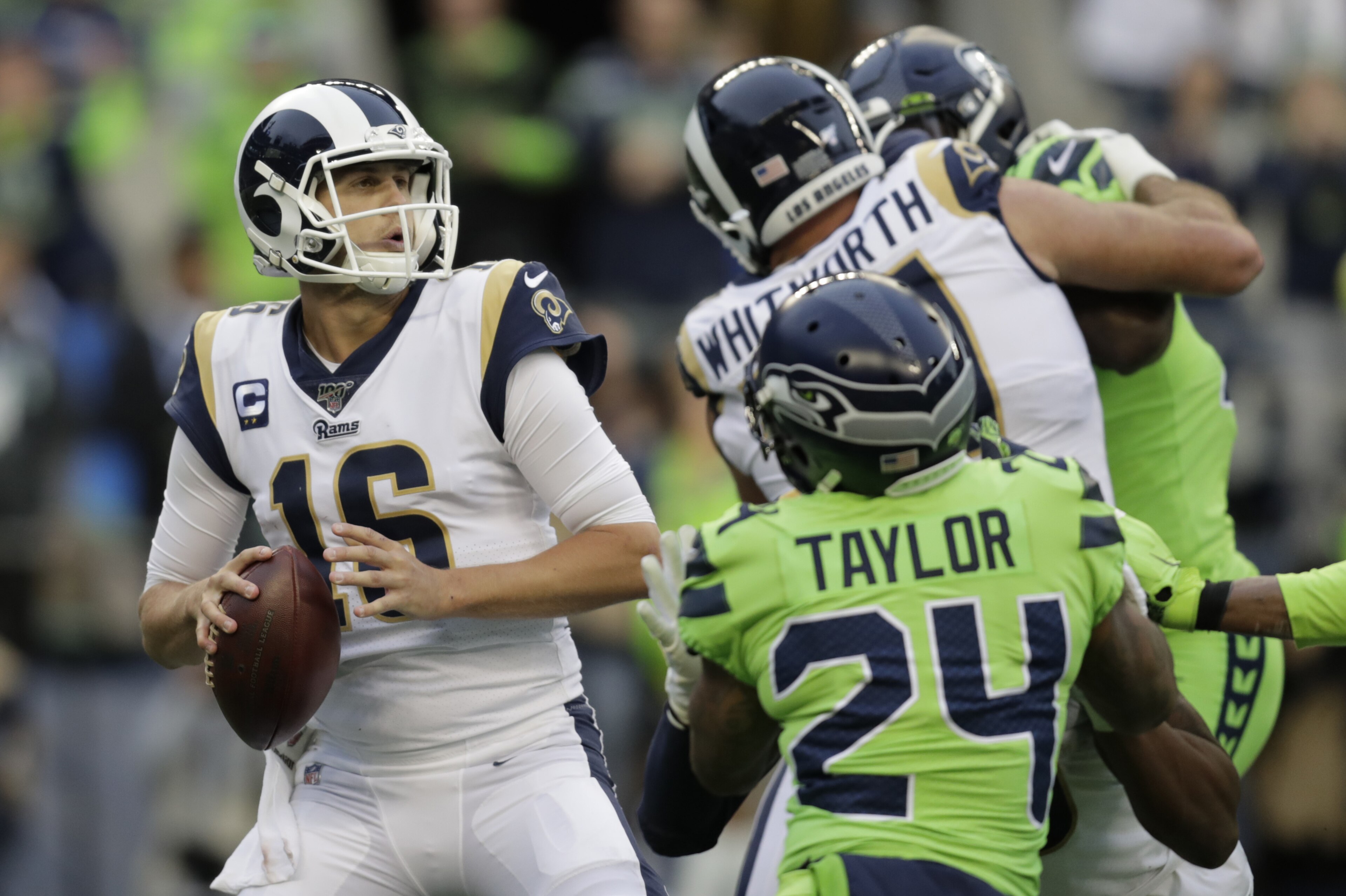 Los Angeles Rams quarterback Jared Goff, left, passes against the Seattle Seahawks during the first half of an NFL football game, Thursday, Oct. 3, 2019, in Seattle. (AP Photo/Stephen Brashear)
