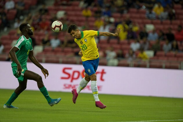Brazil's Roberto Firmino (R) shoots the ball with the head during the friendly international football match between Brazil and Senegal at the National Stadium in Singapore on October 10, 2019. (Photo by Roslan RAHMAN / AFP) (Photo by ROSLAN RAHMAN/AFP via Getty Images)