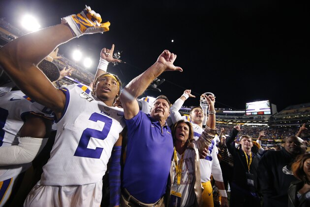 LSU coach Ed Orgeron sings the alma mater with wide receiver Justin Jefferson (2); Orgeron's wife, Kelly; and other team members after LSU's win over Florida in an NCAA college football game in Baton Rouge, La., Saturday, Oct. 12, 2019. LSU won 42-28. (AP Photo/Gerald Herbert)
