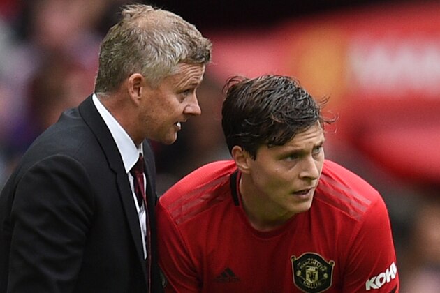 Manchester United's Norwegian manager Ole Gunnar Solskjaer (L) speaks with Manchester United's Swedish defender Victor Lindelof during the English Premier League football match between Manchester United and Chelsea at Old Trafford in Manchester, north west England, on August 11, 2019. (Photo by Oli SCARFF / AFP) / RESTRICTED TO EDITORIAL USE. No use with unauthorized audio, video, data, fixture lists, club/league logos or 'live' services. Online in-match use limited to 120 images. An additional 40 images may be used in extra time. No video emulation. Social media in-match use limited to 120 images. An additional 40 images may be used in extra time. No use in betting publications, games or single club/league/player publications. /         (Photo credit should read OLI SCARFF/AFP/Getty Images)