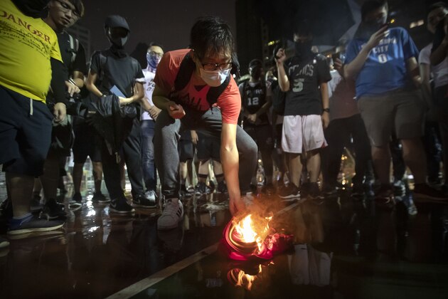 Demonstrators set a Lebron James jersey on fire during a rally at the Southorn Playground in Hong Kong, Tuesday, Oct. 15, 2019. Protesters in Hong Kong have thrown basketballs at a photo of LeBron James and chanted their anger about comments the Los Angeles Lakers star made about free speech during a rally in support of NBA commissioner Adam Silver and Houston Rockets general manager Daryl Morey, whose tweet in support of the Hong Kong protests touched off a firestorm of controversy in China. (AP Photo/Mark Schiefelbein)