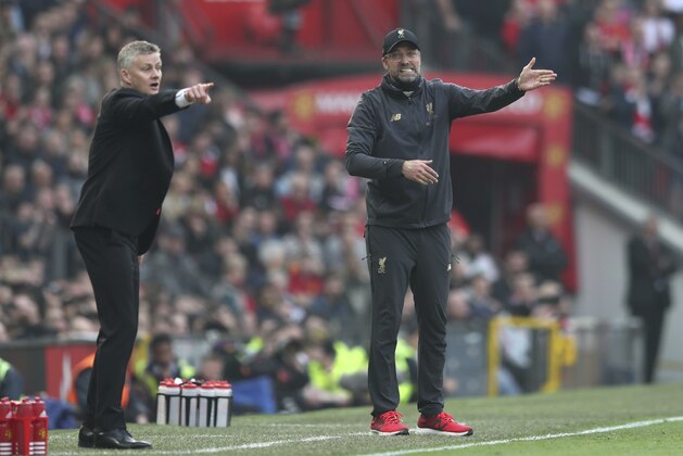 Manchester United manager Ole Gunnar Solskjaer, left, and Liverpool manager Juergen Klopp during the English Premier League soccer match between Manchester United and Liverpool at Old Trafford stadium in Manchester, England, Sunday, Feb. 24, 2019. (AP Photo/Jon Super)