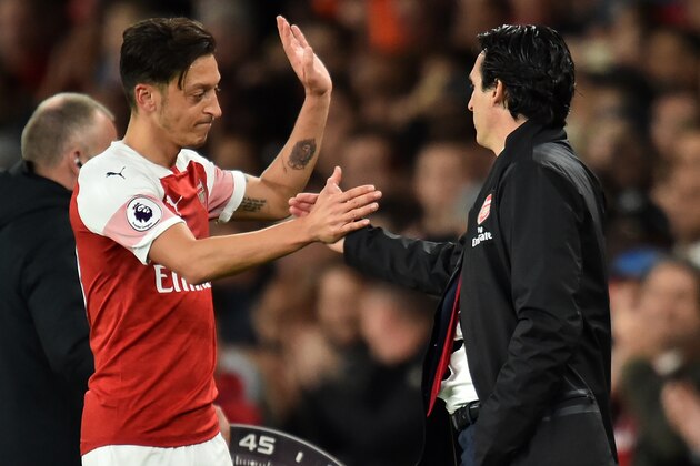 Arsenal's German midfielder Mesut Ozil (L) shakes hands with Arsenal's Spanish head coach Unai Emery (R) after being substituted during the English Premier League football match between Arsenal and Leicester City at the Emirates Stadium in London on October 22, 2018. (Photo by Glyn KIRK / IKIMAGES / AFP) / RESTRICTED TO EDITORIAL USE. No use with unauthorized audio, video, data, fixture lists, club/league logos or 'live' services. Online in-match use limited to 45 images, no video emulation. No use in betting, games or single club/league/player publications.        (Photo credit should read GLYN KIRK/AFP/Getty Images)