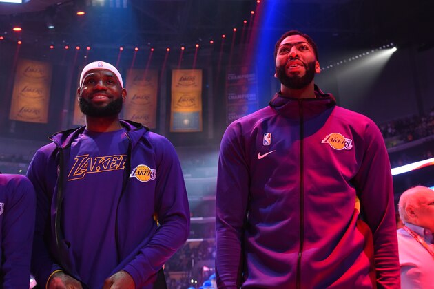 LOS ANGELES, CA - OCTOBER 16: LeBron James #23 and Anthony Davis #3 of the Los Angeles Lakers stand for the National Anthem prior to a pre-season game against the Golden State Warriors on October 16, 2019 at STAPLES Center in Los Angeles, California. NOTE TO USER: User expressly acknowledges and agrees that, by downloading and/or using this Photograph, user is consenting to the terms and conditions of the Getty Images License Agreement. Mandatory Copyright Notice: Copyright 2019 NBAE (Photo by Andrew D. Bernstein/NBAE via Getty Images)