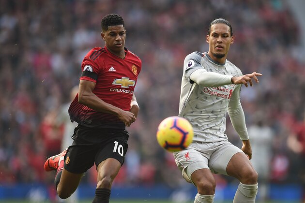 Manchester United's English striker Marcus Rashford (L) and Liverpool's Dutch defender Virgil van Dijk (R) challenge for the ball during the English Premier League football match between Manchester United and Liverpool at Old Trafford in Manchester, north west England, on February 24, 2019. (Photo by Oli SCARFF / AFP) / RESTRICTED TO EDITORIAL USE. No use with unauthorized audio, video, data, fixture lists, club/league logos or 'live' services. Online in-match use limited to 120 images. An additional 40 images may be used in extra time. No video emulation. Social media in-match use limited to 120 images. An additional 40 images may be used in extra time. No use in betting publications, games or single club/league/player publications. /         (Photo credit should read OLI SCARFF/AFP/Getty Images)