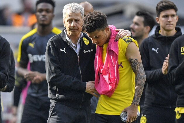 Dortmund coach Lucien Favre comforts Dortmund's Jadon Sancho after the German Bundesliga soccer match between Borussia Moenchengladbach and Borussia Dortmund in Moenchengladbach, Germany, Saturday, May 18, 2019. Dortmund finished the season on the second place behind Bayern Munich. (AP Photo/Martin Meissner)