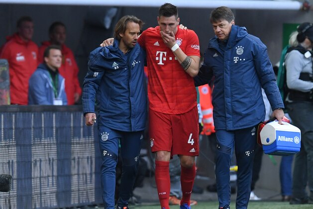 Munich's defender Niklas Suele (C) is helped off after a injury during the German first division Bundesliga football match FC Augsburg v Bayern Munich in Augsburg, southern Germany on October 19 2019. (Photo by Christof STACHE / AFP) / RESTRICTIONS: DFL REGULATIONS PROHIBIT ANY USE OF PHOTOGRAPHS AS IMAGE SEQUENCES AND/OR QUASI-VIDEO (Photo by CHRISTOF STACHE/AFP via Getty Images)