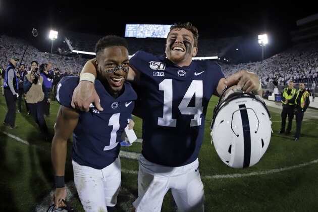 Penn State quarterback Sean Clifford (14) and wide receiver KJ Hamler celebrate the team's 28-21 win over Michigan in an NCAA college football game in State College, Pa., Saturday, Oct. 19, 2019. (AP Photo/Gene J. Puskar)