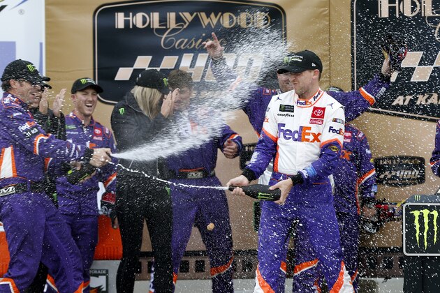 KANSAS CITY, KANSAS - OCTOBER 20: Denny Hamlin, driver of the #11 FedEx Office Toyota, celebrates in Victory Lane after winning the Monster Energy NASCAR Cup Series Hollywood Casino 400 at Kansas Speedway on October 20, 2019 in Kansas City, Kansas. (Photo by Brian Lawdermilk/Getty Images)