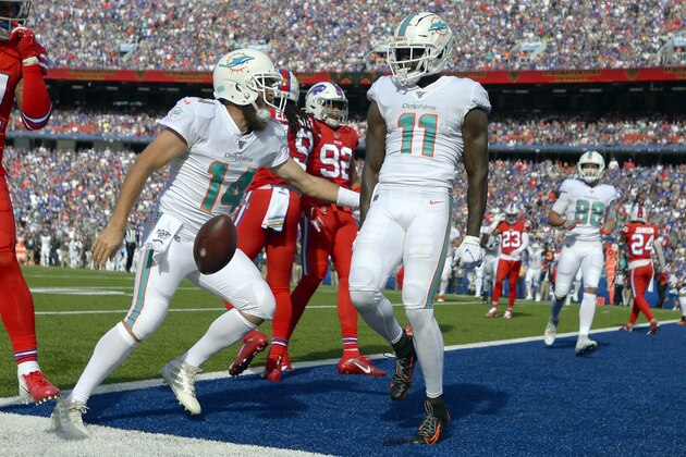 Miami Dolphins quarterback Ryan Fitzpatrick, left, celebrates his touchdown pass to wide receiver DeVante Parker, right, in the first half of an NFL football game against the Buffalo Bills, Sunday, Oct. 20, 2019, in Orchard Park, N.Y. (AP Photo/Adrian Kraus)