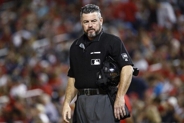 FILE - In this Sept. 13, 2019, file photo, umpire Rob Drake stands on the field during a baseball game between the Atlanta Braves and the Washington Nationals in Washington. Commissioner Rob Manfred says Major League Baseball will look into a politicized tweet by Drake that referenced a rifle and criticism of President Donald Trump. (AP Photo/Patrick Semansky, File)