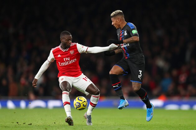 LONDON, ENGLAND - OCTOBER 27: Nicolas Pepe of Arsenal is challenged by Patrick van Aanholt of Crystal Palace during the Premier League match between Arsenal FC and Crystal Palace at Emirates Stadium on October 27, 2019 in London, United Kingdom. (Photo by Catherine Ivill/Getty Images)