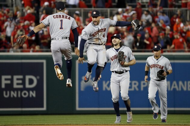 Houston Astros shortstop Carlos Correa, left, and right fielder George Springer celebrate after their teams win against the Washington Nationals in Game 5 of the baseball World Series Sunday, Oct. 27, 2019, in Washington. The Astros won 7-1 to take a 3-2 lead in the series. (AP Photo/Jeff Roberson)