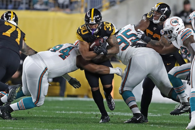 Pittsburgh Steelers running back James Conner (30) is tackled by Miami Dolphins defensive tackles Christian Wilkins (94) and John Jenkins (95) during the first half of an NFL football game in Pittsburgh, Monday, Oct. 28, 2019. (AP Photo/Keith Srakocic)