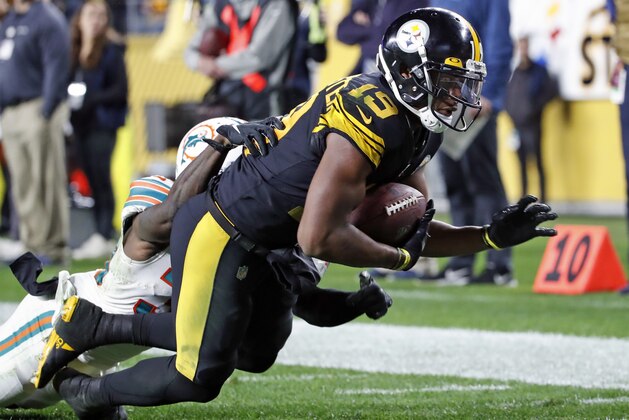 Pittsburgh Steelers wide receiver JuJu Smith-Schuster (19) falls into the end zone for a touchdown after taking a pass from quarterback Mason Rudolph with Miami Dolphins defensive back Chris Lammons (30) defending during the second half of an NFL football game in Pittsburgh, Monday, Oct. 28, 2019. (AP Photo/Don Wright)