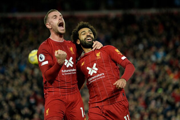 Liverpool's Egyptian midfielder Mohamed Salah (R) celebrates with Liverpool's English midfielder Jordan Henderson after scoring a penalty during the English Premier League football match between Liverpool and Tottenham Hotspur at Anfield in Liverpool, north west England on October 27, 2019. (Photo by STRINGER / AFP) / RESTRICTED TO EDITORIAL USE. No use with unauthorized audio, video, data, fixture lists, club/league logos or 'live' services. Online in-match use limited to 120 images. An additional 40 images may be used in extra time. No video emulation. Social media in-match use limited to 120 images. An additional 40 images may be used in extra time. No use in betting publications, games or single club/league/player publications. /  (Photo by STRINGER/AFP via Getty Images)